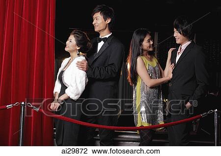 Young people standing behind red rope at night View Large Photo Image Stock Image - Young people standing behind red rope at night. Fotosearch