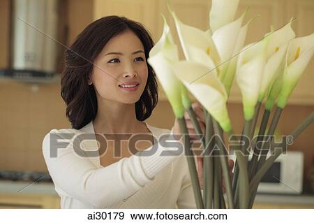 Young woman arranging flowers View Large Photo Image Stock Photo - Young woman arranging flowers. Fotosearch