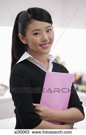 Young woman holding pink folder and smiling View Large Photo Image Stock Image - Young woman holding pink folder and smiling. Fotosearch