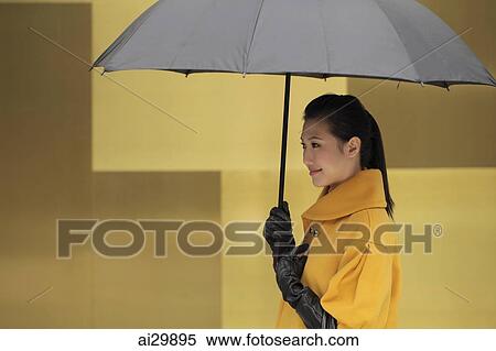 Young woman in coat and gloves holding an umbrella View Large Photo Image Stock Photography - Young woman in coat and gloves holding an umbrella. Fotosearch