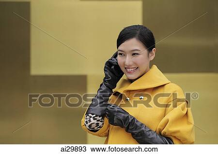 Young woman in coat and gloves talking on phone View Large Photo Image Stock Image - Young woman in coat and gloves talking on phone. Fotosearch