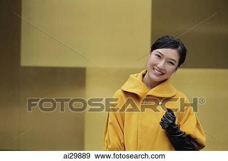Young woman in yellow coat smiling View Large Photo Image Stock Photo - Young woman in yellow coat smiling. Fotosearch