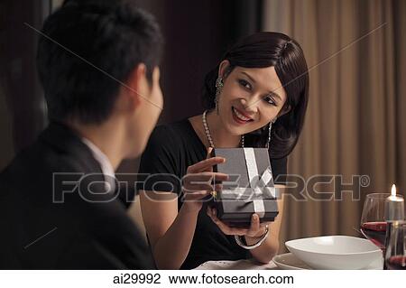 Young woman opening a present and smiling View Large Photo Image Stock Image - Young woman opening a present and smiling. Fotosearch