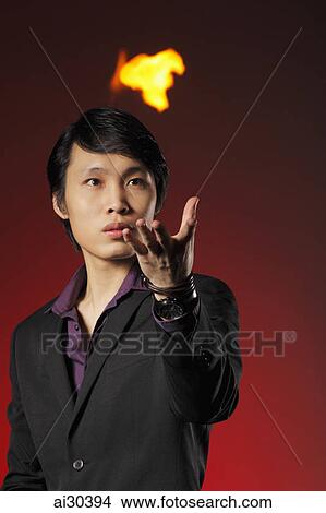 A magician holds a ball of flames in the air View Large Photo Image Picture - A magician holds a ball of flames in the air. Fotosearch