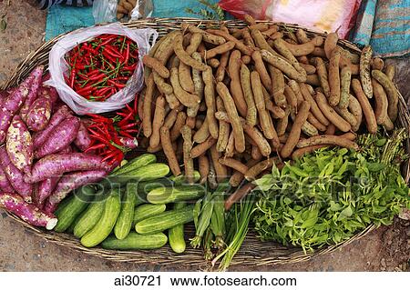 Stock Image - A woven basket of different vegetables sold in a market, Siem Reap, Cambodia. Fotosearch