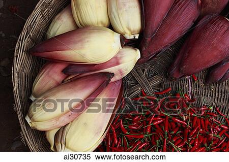 Stock Photography - Banana flowers and chillies in woven basket, Cambodia. Fotosearch