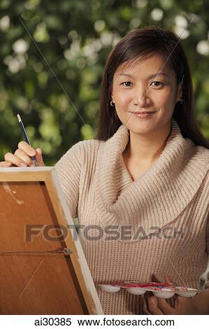 Cropped shot of woman painting on an easel outdoors View Large Photo Image Stock Photography - Cropped shot of woman painting on an easel outdoors. Fotosearch