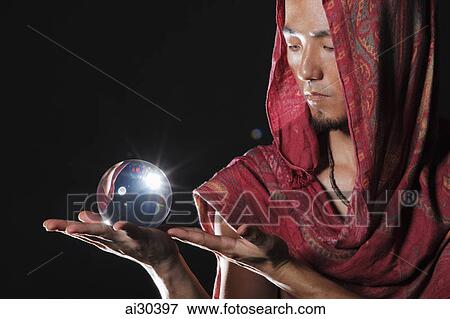 Fortune teller holding a crystal ball View Large Photo Image Stock Photo - Fortune teller holding a crystal ball. Fotosearch