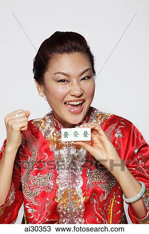 Happy woman wearing Chinese jacket and holding matching Mahjong tiles which mean "Jack pot" View Large Photo Image Stock Image - Happy woman wearing Chinese jacket and holding matching Mahjong tiles which mean "Jack pot". Fotosearch