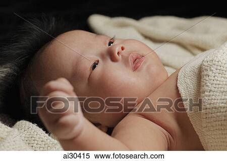 Stock Photography - Head shot of a baby boy laying down. Fotosearch