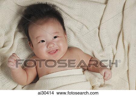 Head shot of a baby boy wrapped in a blanket smiling View Large Photo Image Picture - Head shot of a baby boy wrapped in a blanket smiling. Fotosearch