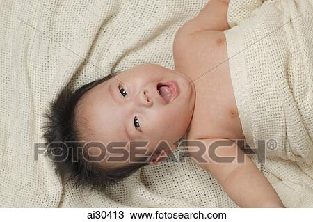 Stock Image - Head shot of a baby boy wrapped in a blanket. Fotosearch