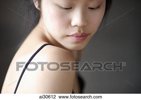Stock Image - Head shot of woman looking over her shoulder. Fotosearch