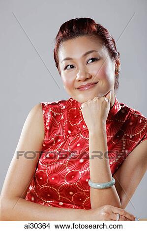 Picture - Head shot of woman looking up with chin resting on hand. Fotosearch