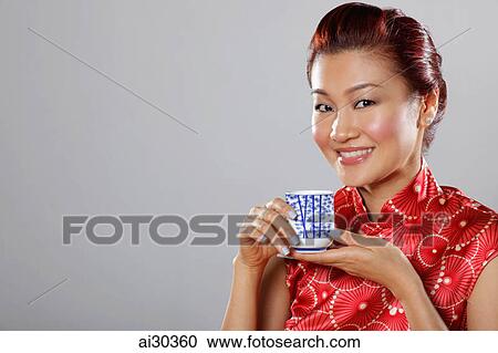 Head shot of woman wearing Cheongsam holding tea cup View Large Photo Image Stock Image - Head shot of woman wearing Cheongsam holding tea cup. Fotosearch