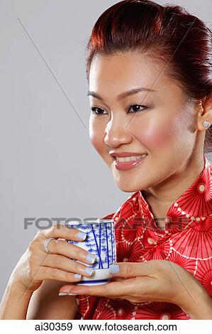 Head shot of woman wearing Cheongsam holding tea cup View Large Photo Image Stock Photo - Head shot of woman wearing Cheongsam holding tea cup. Fotosearch