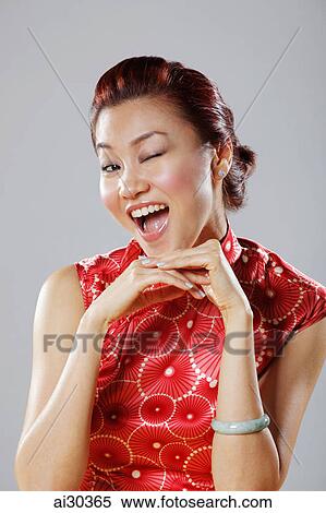 Stock Photography - Head shot of woman wearing Cheongsam and winking. Fotosearch