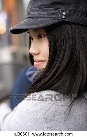 Head shot of young woman wearing a cap View Large Photo Image Stock Image - Head shot of young woman wearing a cap. Fotosearch