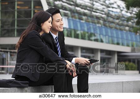 Man and woman in business attire holding a digital tablet View Large Photo Image Stock Photo - Man and woman in business attire holding a digital tablet. Fotosearch