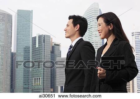 Man and woman wearing business attire in front of buildings View Large Photo Image Stock Image - Man and woman wearing business attire in front of buildings. Fotosearch