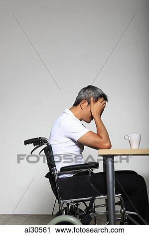 Man sitting in a wheelchair with head in hands feeling sad View Large Photo Image Stock Image - Man sitting in a wheelchair with head in hands feeling sad. Fotosearch