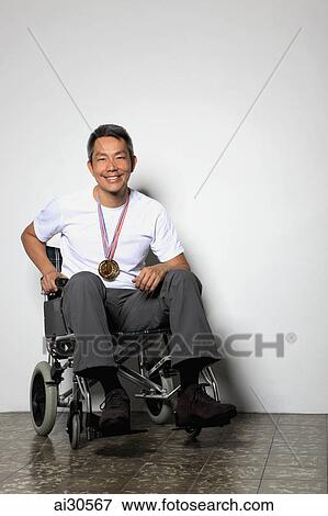 Mature man sitting in a wheelchair wearing a medal and smiling View Large Photo Image Stock Photo - Mature man sitting in a wheelchair wearing a medal and smiling. Fotosearch