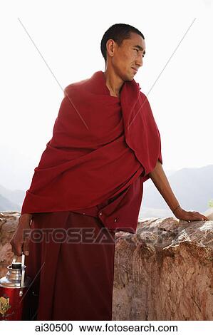 Monk holding a water flask and looking over a wall, Likir Monastery, Ladakh, India View Large Photo Image Stock Image - Monk holding a water flask and looking over a wall, Likir Monastery, Ladakh, India. Fotosearch