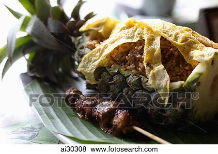 Pineapple fried rice in a pineapple on a banana leaf View Large Photo Image Stock Photo - Pineapple fried rice in a pineapple on a banana leaf. Fotosearch