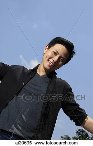Portrait of young man smiling outside View Large Photo Image Stock Photography - Portrait of young man smiling outside. Fotosearch