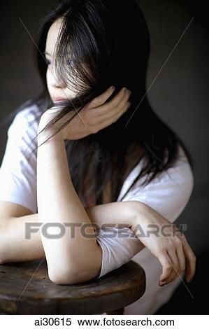 Stock Photography - Portrait of young woman with long hair looking away. Fotosearch