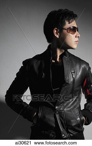 Stock Image - Profile of young man wearing sunglasses and leather jacket.. Fotosearch