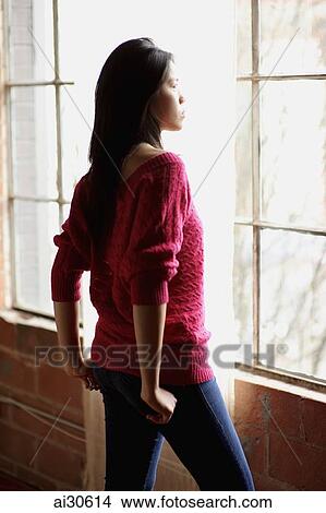 Profile of young woman looking out the window View Large Photo Image Picture - Profile of young woman looking out the window. Fotosearch