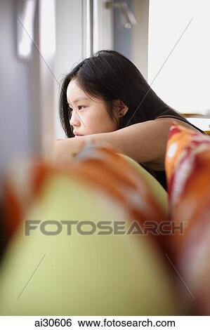 Profile shot of young woman looking out the window View Large Photo Image Stock Photograph - Profile shot of young woman looking out the window. Fotosearch