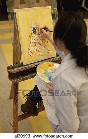 Rear view of young woman painting on an easel. View Large Photo Image Stock Image - Rear view of young woman painting on an easel.. Fotosearch