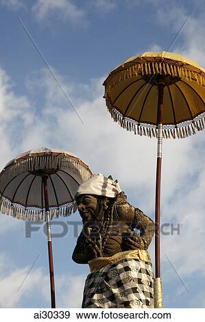 Stone carving of Balinese Deity under Balinese umbrellas. Indonesia, Bali View Large Photo Image Stock Photo - Stone carving of Balinese Deity under Balinese umbrellas. Indonesia, Bali. Fotosearch