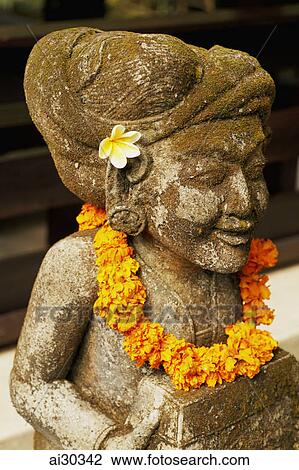 Stone carving of Balinese Deity with flowers. Indonesia, Bali View Large Photo Image Stock Image - Stone carving of Balinese Deity with flowers. Indonesia, Bali. Fotosearch