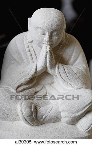 Stock Photography - Stone carving of Buddha praying. Fotosearch