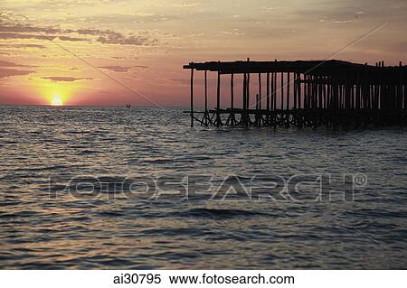 Sunset setting in the ocean with wooden pier in foreground, Cambodia View Large Photo Image Stock Photography - Sunset setting in the ocean with wooden pier in foreground, Cambodia. Fotosearch