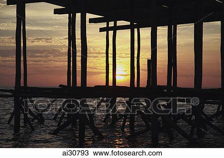 Sunset shining through a wooden pier, Cambodia View Large Photo Image Stock Image - Sunset shining through a wooden pier, Cambodia. Fotosearch
