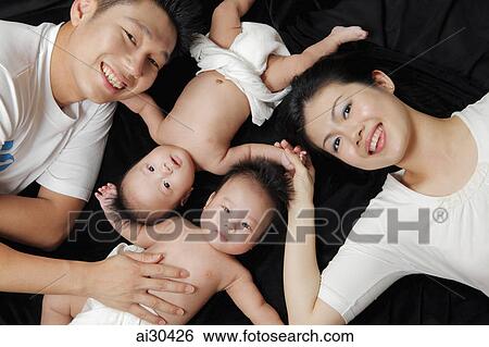 Stock Photograph - Top view of mother, father and their twin babies. Fotosearch
