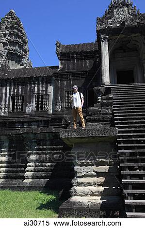 Tourist holding camera standing on steps of Angkor Wat, Cambodia View Large Photo Image Stock Photography - Tourist holding camera standing on steps of Angkor Wat, Cambodia. Fotosearch
