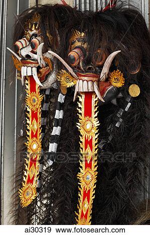 Stock Photo - Traditional Balinese wooden masks hanging in a market, Indonesia, Bali. Fotosearch