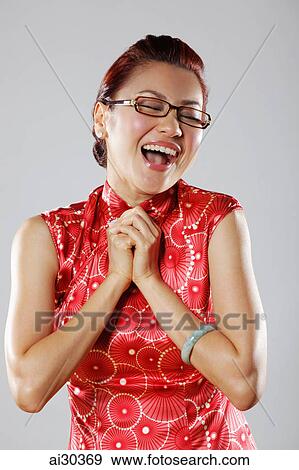 Woman clasping hands to chest and smiling View Large Photo Image Stock Photo - Woman clasping hands to chest and smiling. Fotosearch