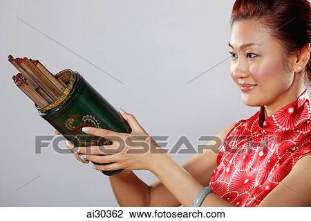 Stock Image - Woman holding Kau Cim (Chinese Fortune Sticks).. Fotosearch