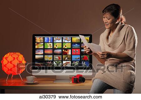 Woman looking at photographs on a computer. View Large Photo Image Stock Photo - Woman looking at photographs on a computer.. Fotosearch