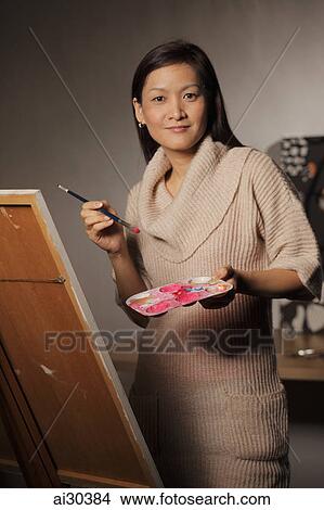 Woman painting on an easel View Large Photo Image Picture - Woman painting on an easel. Fotosearch