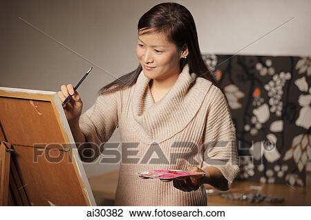 Woman painting on an easel. View Large Photo Image Stock Image - Woman painting on an easel.. Fotosearch