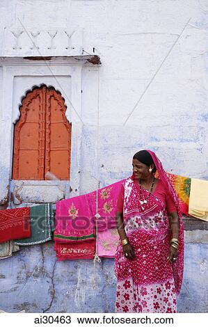 Stock Image - Woman selling saris outside Sadar Market, Jodhpur, India. Fotosearch