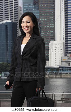 Woman wearing business suit standing in front of buildings. View Large Photo Image Stock Photography - Woman wearing business suit standing in front of buildings.. Fotosearch