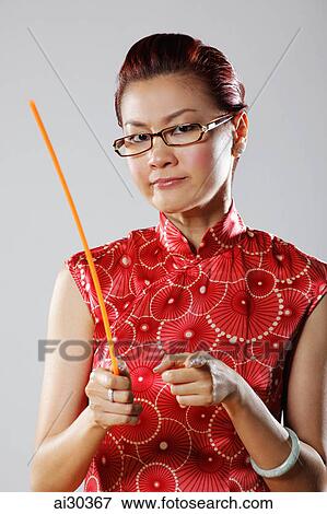 Woman wearing Cheongsam looking angry and holding a stick View Large Photo Image Stock Photo - Woman wearing Cheongsam looking angry and holding a stick. Fotosearch